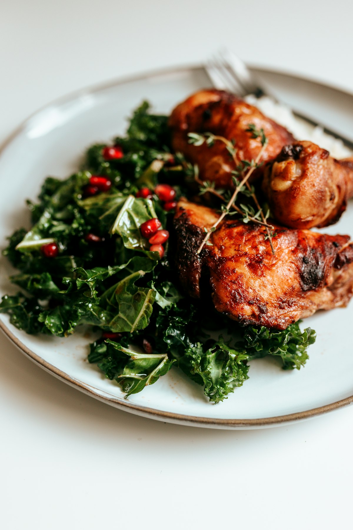 Jerk chicken plated with kale and pomegranate at Royal Jerk